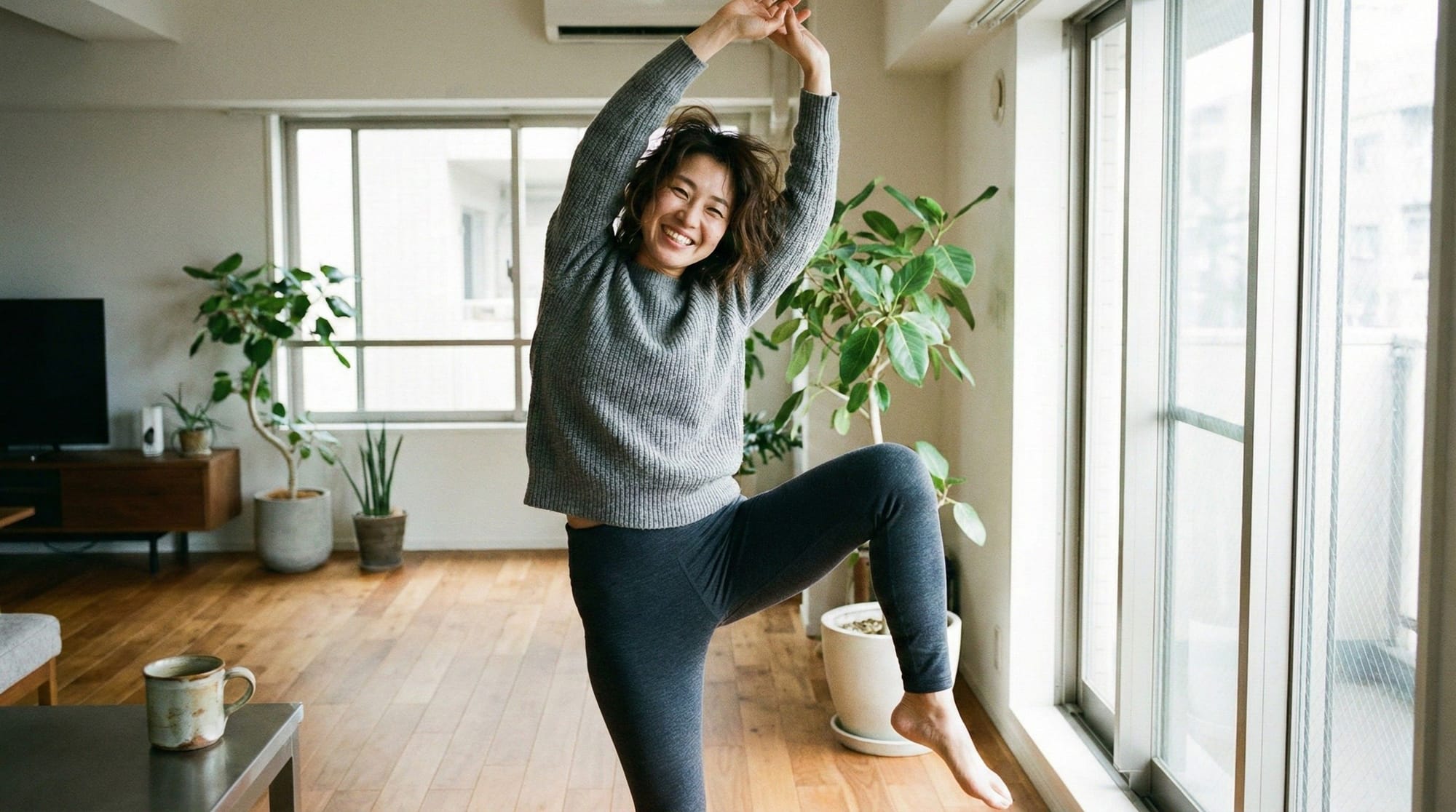 An Asian Woman in her 30s stretching joyfully at home