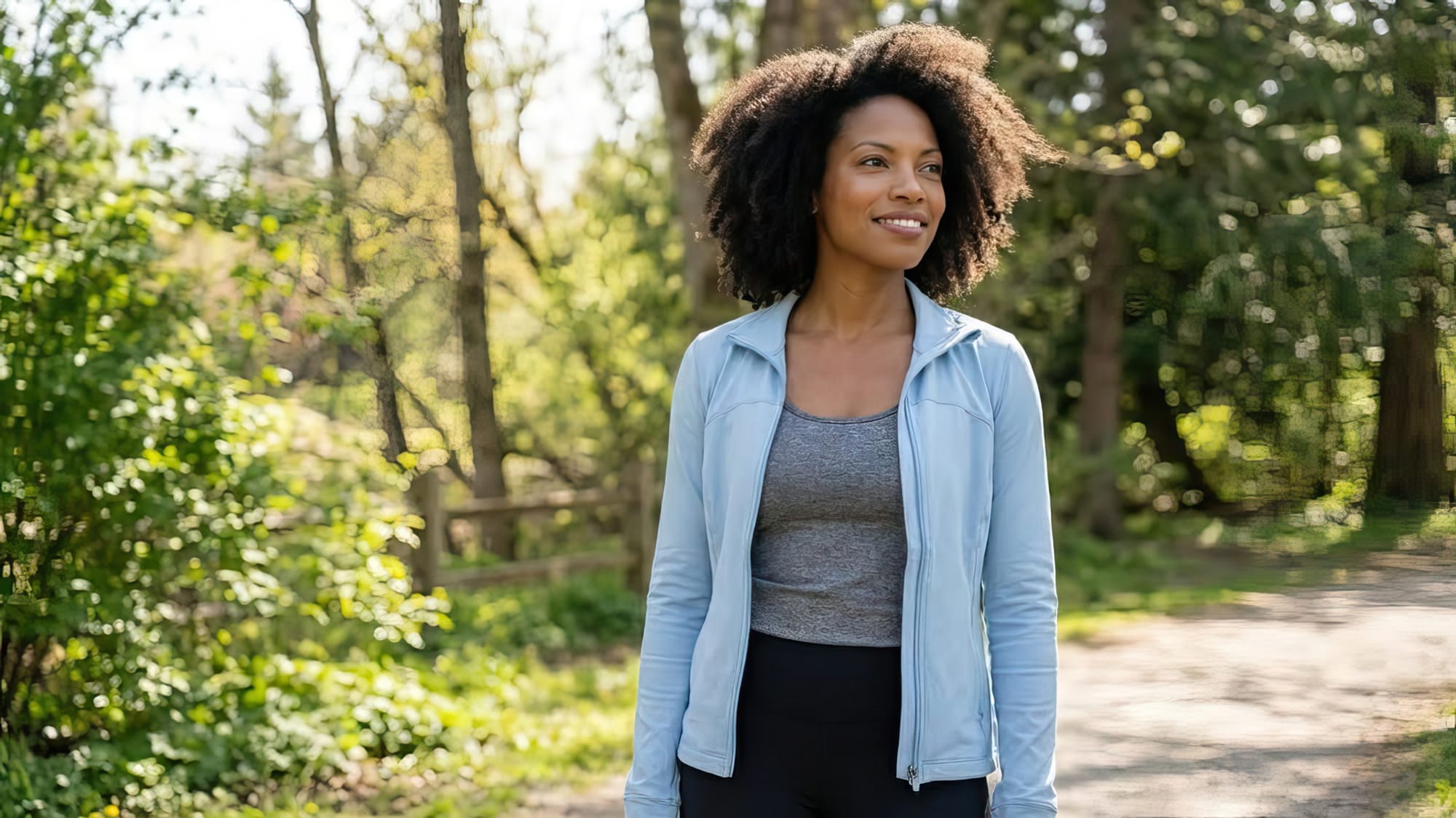 A black woman standing confidently outdoors in a moment of calm reflection and empowerment. 